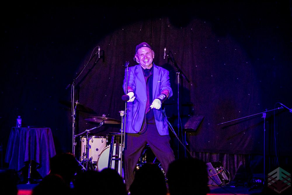 Performer in a purple suit with a spotlight
